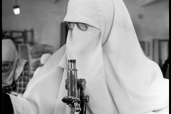 EGYPT. Cairo. 1987. Veiled Muslim fundamentalist student looks in a mycroscope in the biology lab of the University.