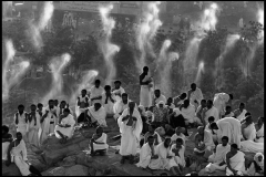 SAUDI ARABIA. Mecca. 1992. Hajj pilgrimage. Pilgrims from all over the world pray on Mount Rahma. Mount Rahma, in the plain of Arafat (where Muslims believe Adam met Eve). Pilgrims dressed in the Ihram (two pieces of unstitched white cloth), gather to show their respect for all forms of life. Driplets of water cool off pilgrims and trees from the dense heat.